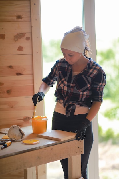 Foto vrouw met borstelreparatie in een houten huis