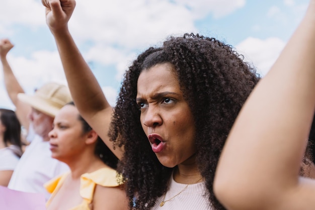 Vrouw met boze uitdrukking vuist opgeheven in protestmars