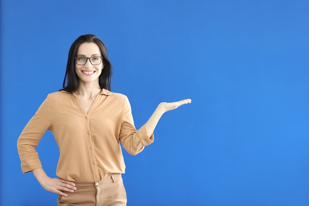 Vrouw met bril handgebaar tonen op blauwe achtergrond