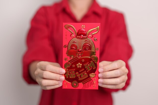 Vrouw met Chinese rode envelop met gouden konijn en zegenend woord geld cadeau voor gelukkige nieuwe maanjaar vakantie Chinese zin betekent geluk gezond Lucky en Wealthy