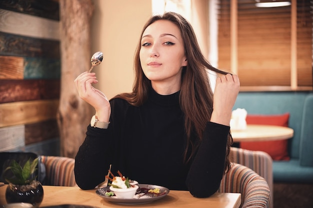 Vrouw met chocoladehaar brownie cake dessert eten in café met veel plezier