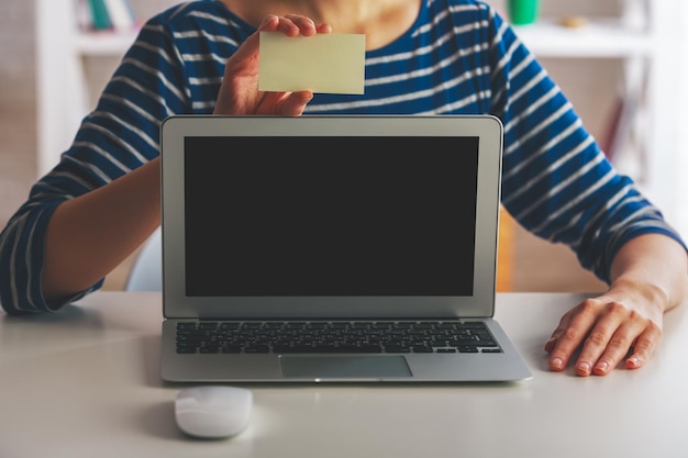 Vrouw met computer met visitekaartje