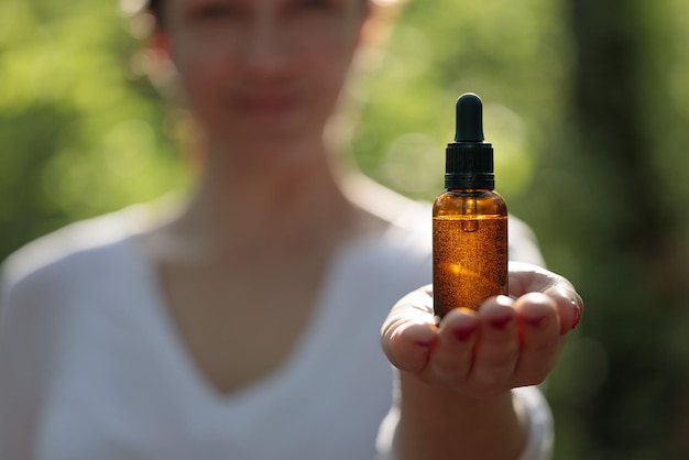 Vrouw met cosmetisch elixer in amberbruine fles