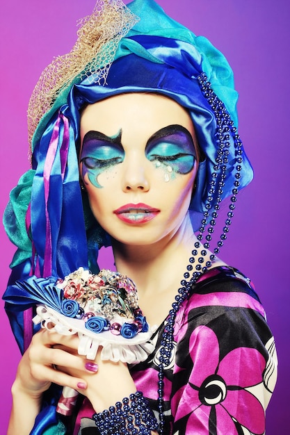 Vrouw met creatieve make-up met een boeket juwelen