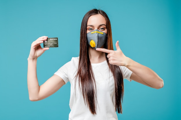 Vrouw met creditcard die gasmasker draagt