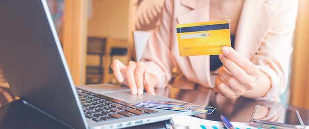 Vrouw met creditcard en met behulp van laptop online winkelen. voor webbanner.