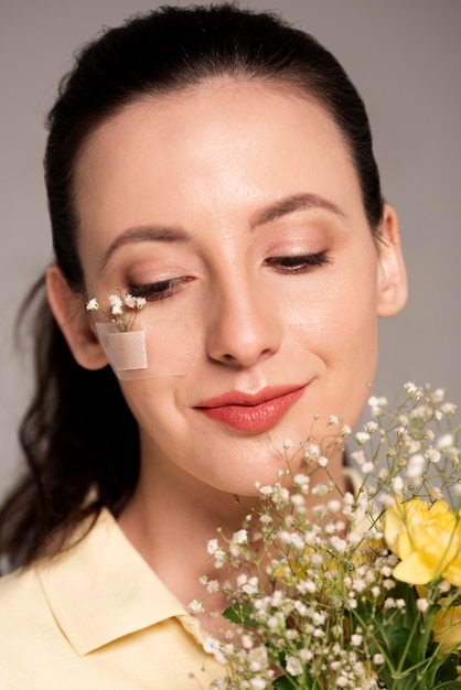 Vrouw met de bloem van de bandhulp op gezicht