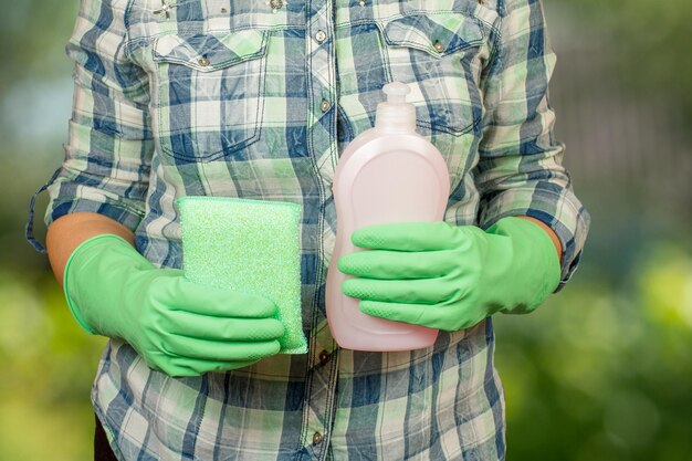 Vrouw met de fles afwasmiddel en de vod