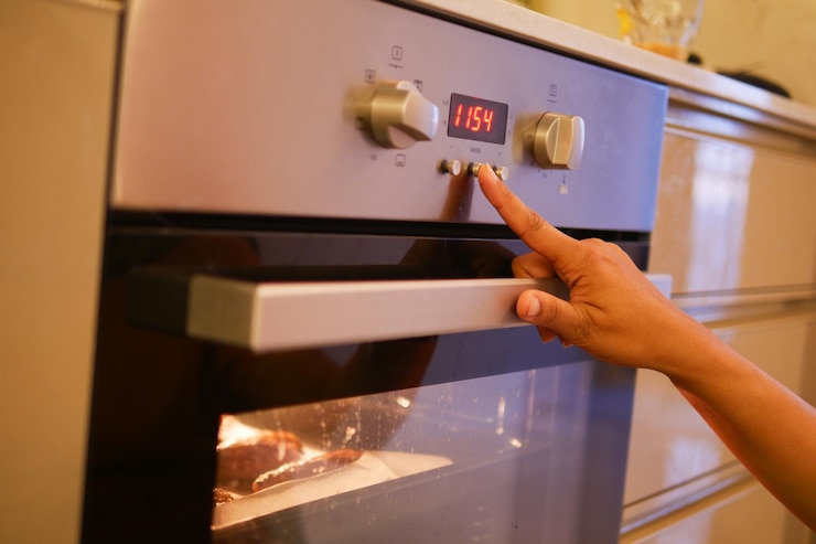 Foto vrouw met de hand de temperatuurregeling op de oven instelt