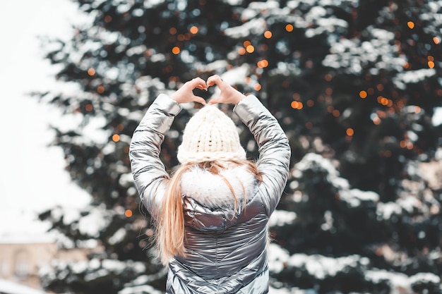 Foto vrouw met de kerstboom toont het hart