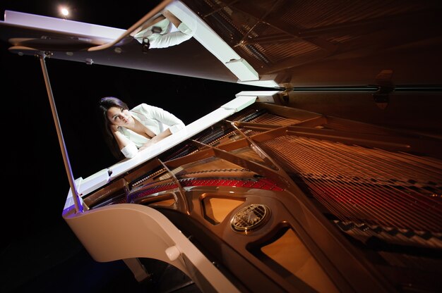 Vrouw met de witte piano op het podium.