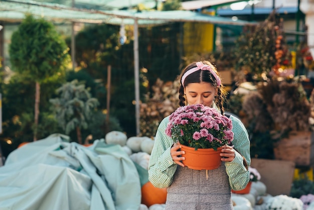 Vrouw met decoratieve bloem in bloempot op de markt