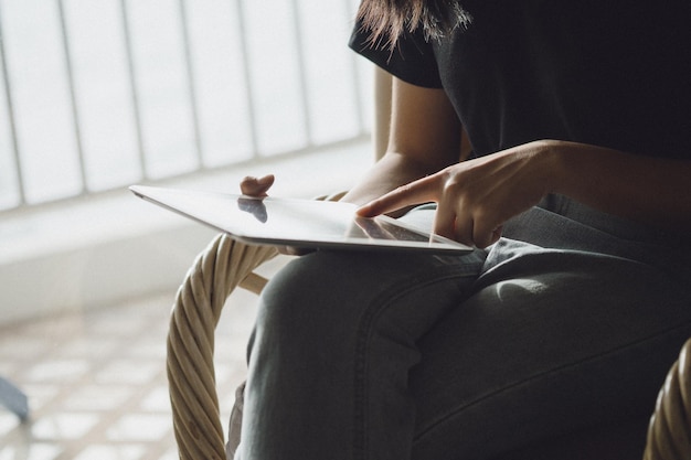 Vrouw met digitale tablet op stoel