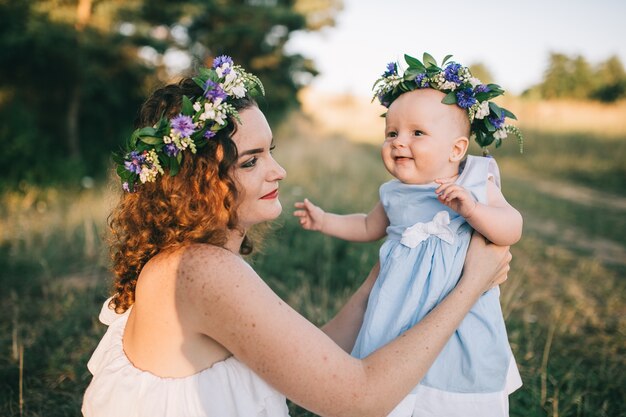 Vrouw met dochter in bloemenkransen