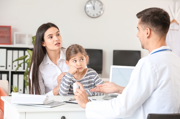 Vrouw met dochtertje kinderarts in kliniek bezoeken