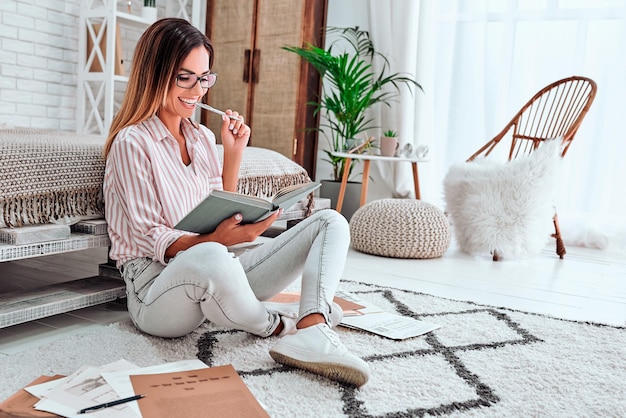 vrouw met donker haar schrijft in notitieboekje veel plannen voor komende weekenden Copywriter werkt thuis