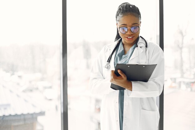 Vrouw met dreadlocks. Dokter met een donkere huid. Vrouw in een ziekenhuisjurk.