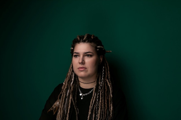 Vrouw met dreadlocks voor de groene muur