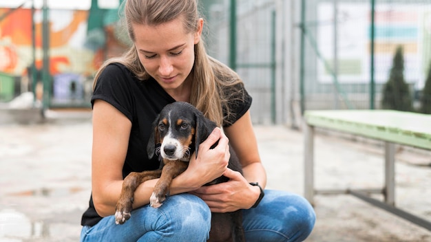 Vrouw met droevige reddingshond bij adoptieopvang