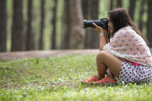 Vrouw met DSLR camera-opnamen poseren