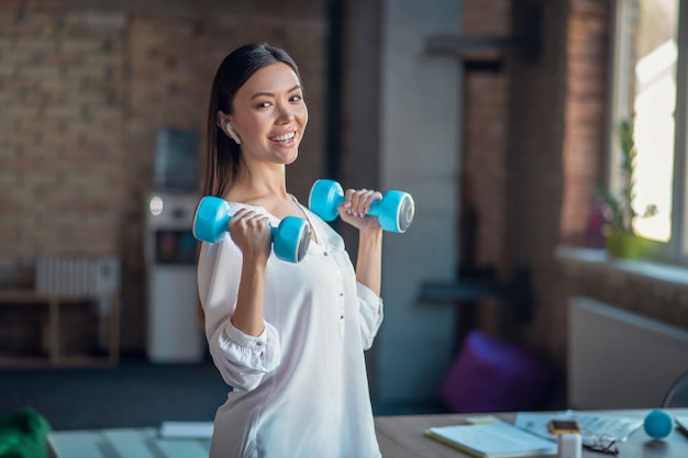 Vrouw met dumbells tijdens het sporten