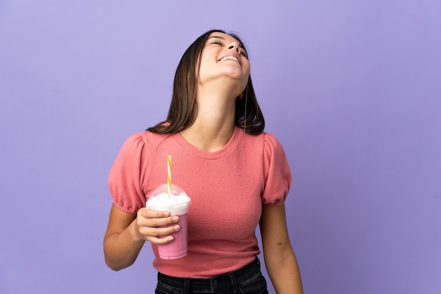 Vrouw met een aardbei milkshake lachen