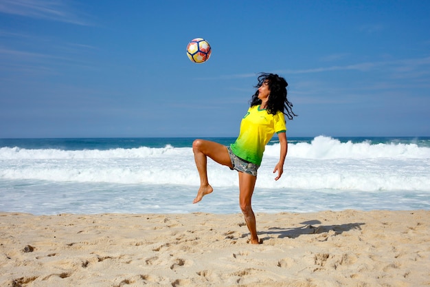 Vrouw met een bal spelen op het strand