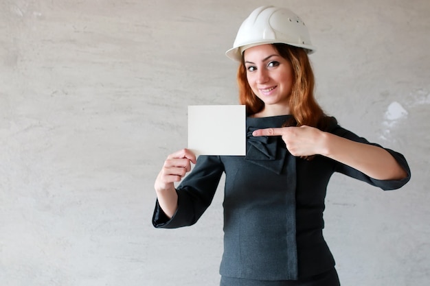 Vrouw met een blanco vel papier in zijn hand op een bouwplaats