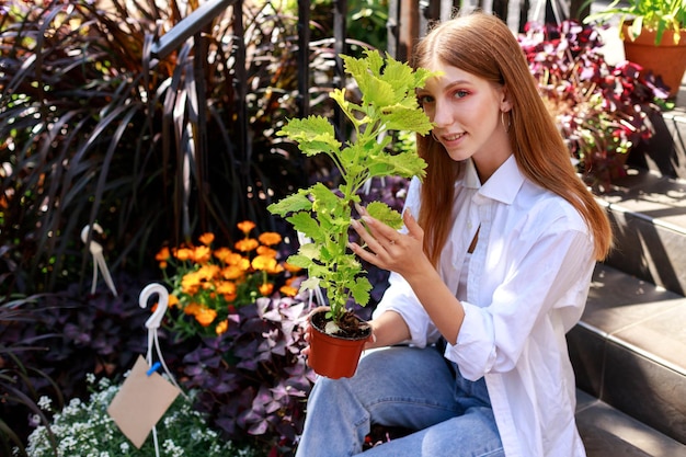 Vrouw met een bloem in een pot op een bloemenmarkt