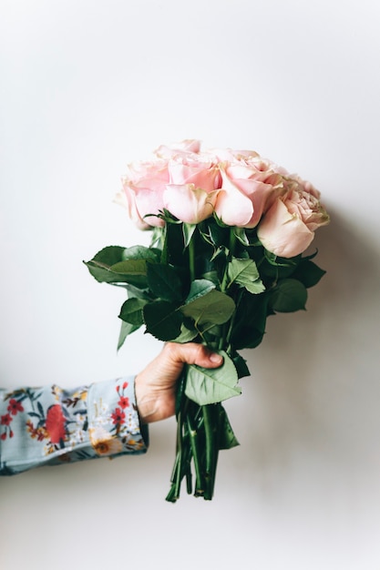 Vrouw met een boeket bloemen bij de muur