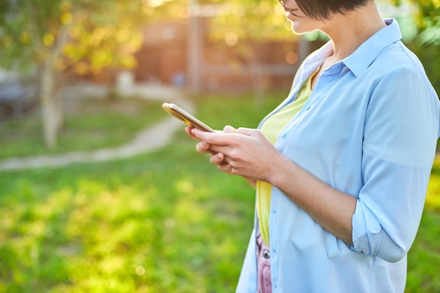 Vrouw met een bril die berichten van het type smartphone op mobiele telefoon gebruikt