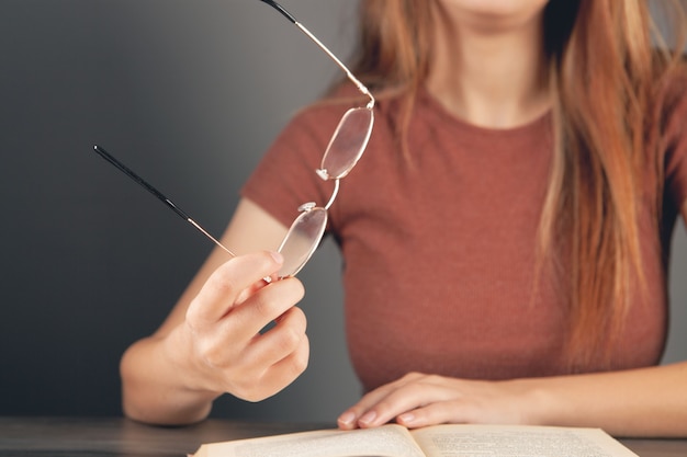 Vrouw met een bril voor een boek