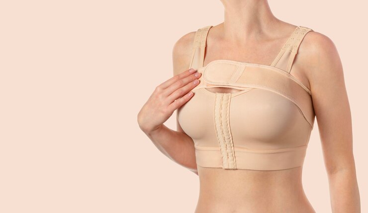Vrouw met een compressieve beha met een stipe na een borstvergrotingsoperatie