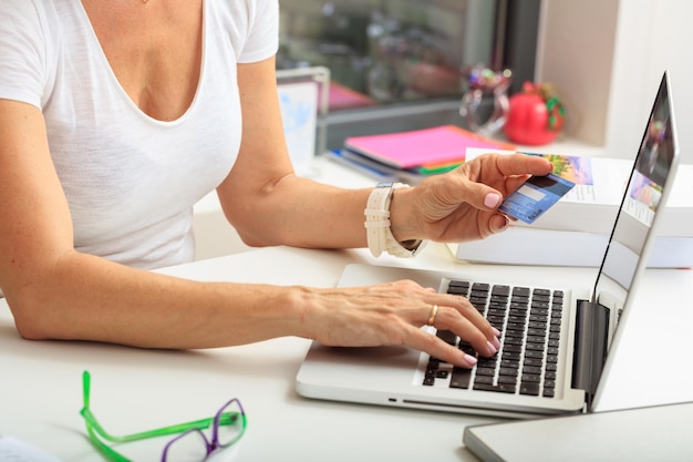 Vrouw met een creditcard op een kantoorachtergrond