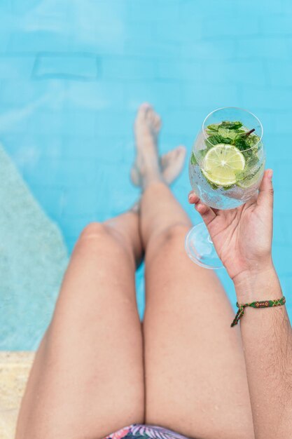 Vrouw met een drankje en ontspannen in een zwembad