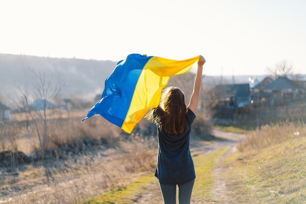 Vrouw met een gele en blauwe vlag van Oekraïne in de buitenlucht