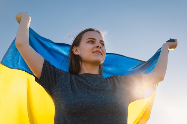 Vrouw met een gele en blauwe vlag van Oekraïne in de buitenlucht