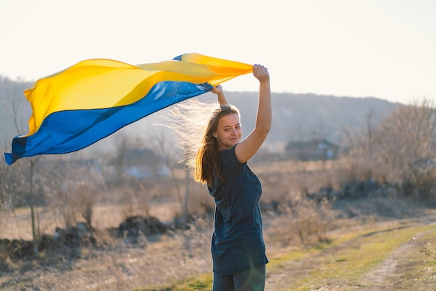 Vrouw met een gele en blauwe vlag van oekraïne in de buitenlucht