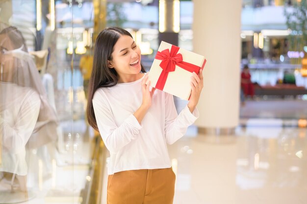 Vrouw met een geschenkdoos in winkelcentrum