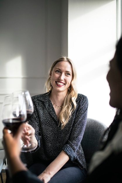 Vrouw met een glas rode wijn met vrienden