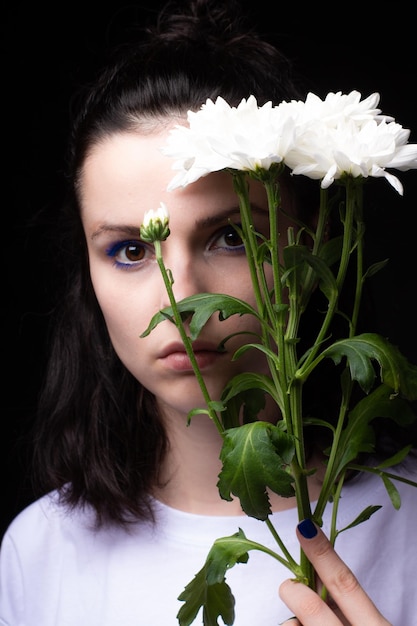 vrouw met een groot boeket chrysanten zwarte achtergrond