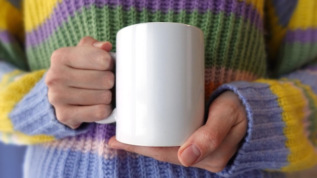 Foto vrouw met een hand die een witte theekop ceramische koffiekopje vasthoudt
