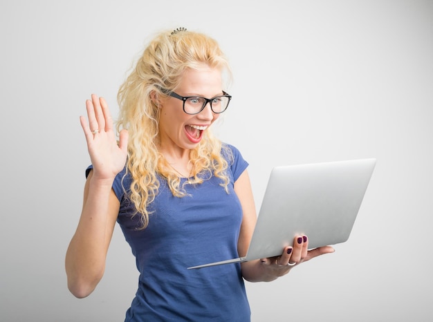 Foto vrouw met één hand omhoog kijkend naar computer