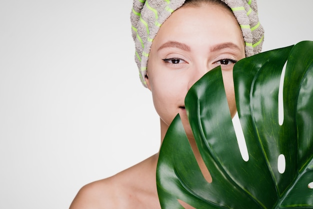 Vrouw met een handdoek op haar hoofd met een groot blad