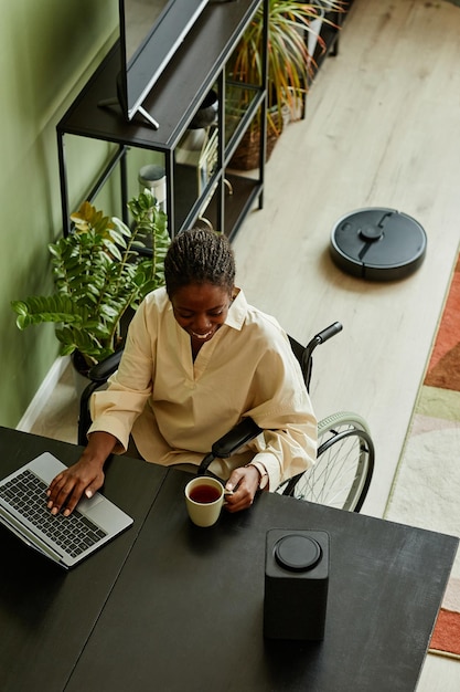 Vrouw met een handicap die Smart Speaker thuis gebruikt