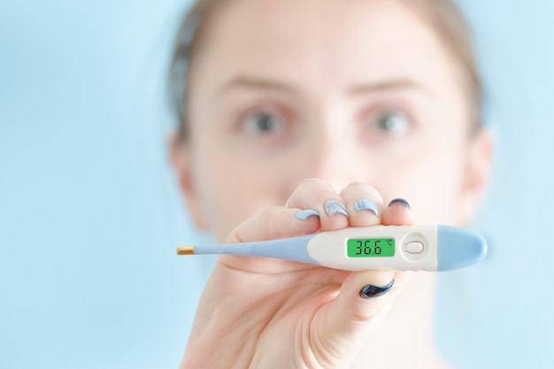 Vrouw met een in hand thermometer