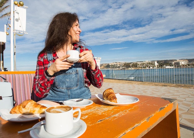 Foto vrouw met een koffiekop op tafel