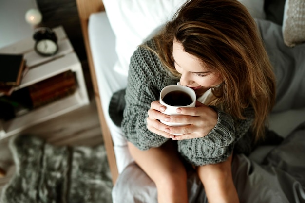 Foto vrouw met een koffiekopje thuis