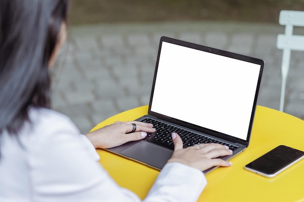 Vrouw met een laptop die naar een zwart scherm kijkt en online werkt en op een werkplek zit