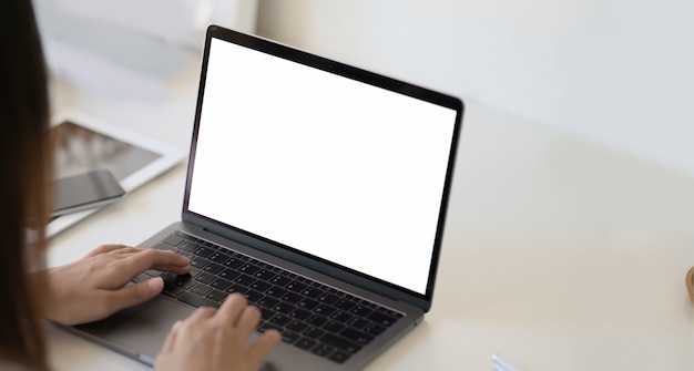 Vrouw met een laptop op een wit bureaublad